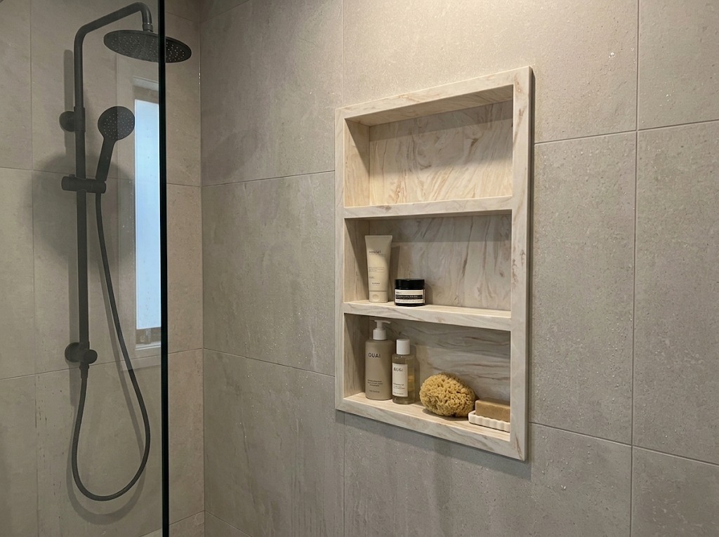 Nicho de ducha em Corian com prateleiras integradas, projeto residencial no Algarve